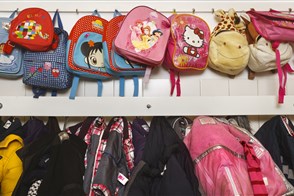Rugzakjes van kinderen in opvang aan de muur