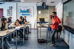 Docent staat voor de klas. Een innovatief experiment vindt plaats op het Vechtstedecollege in Weesp, waar ze experimenteren met kortere lesuren en minder onderwijstijd per dag.